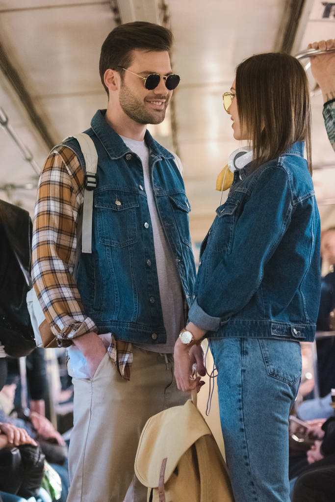 elegante pareja de turistas en gafas de sol hablando en metro tren
  - Foto, imagen