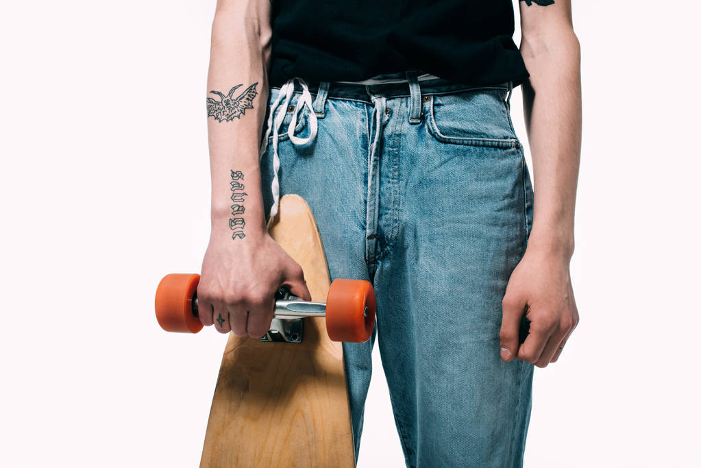 Obcięty widok człowieka w dżinsy, trzymając longboard na białym tle - Zdjęcie, obraz