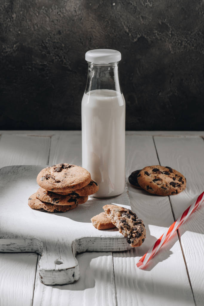 смачне печиво з шоколадом з пляшкою молока на дерев'яній дошці
 - Фото, зображення