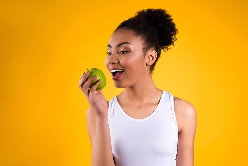 Chica afroamericana sosteniendo manzana aislada
. - Foto, imagen