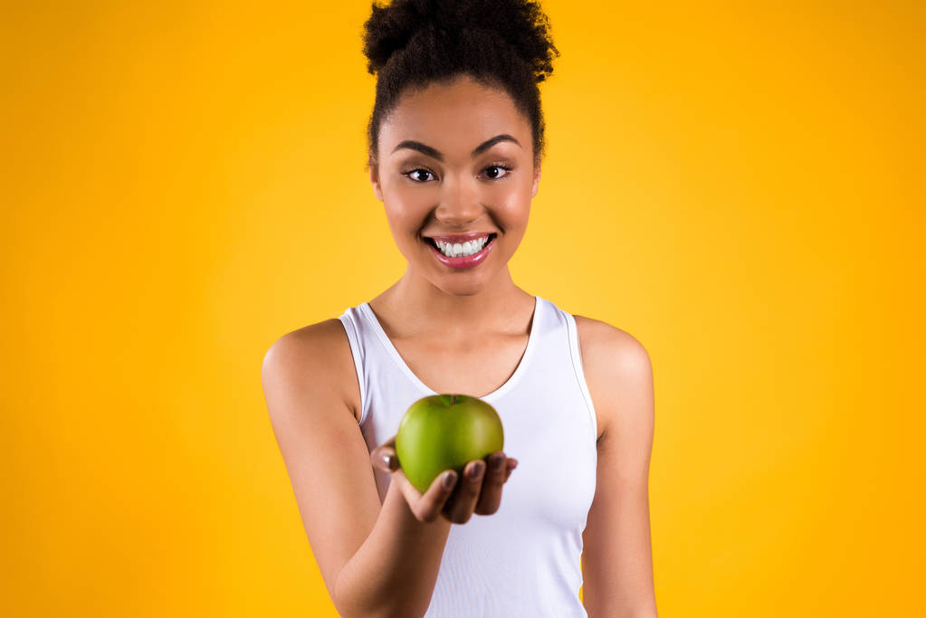 Portret van zwarte meid met groene appel geïsoleerd. - Foto, afbeelding