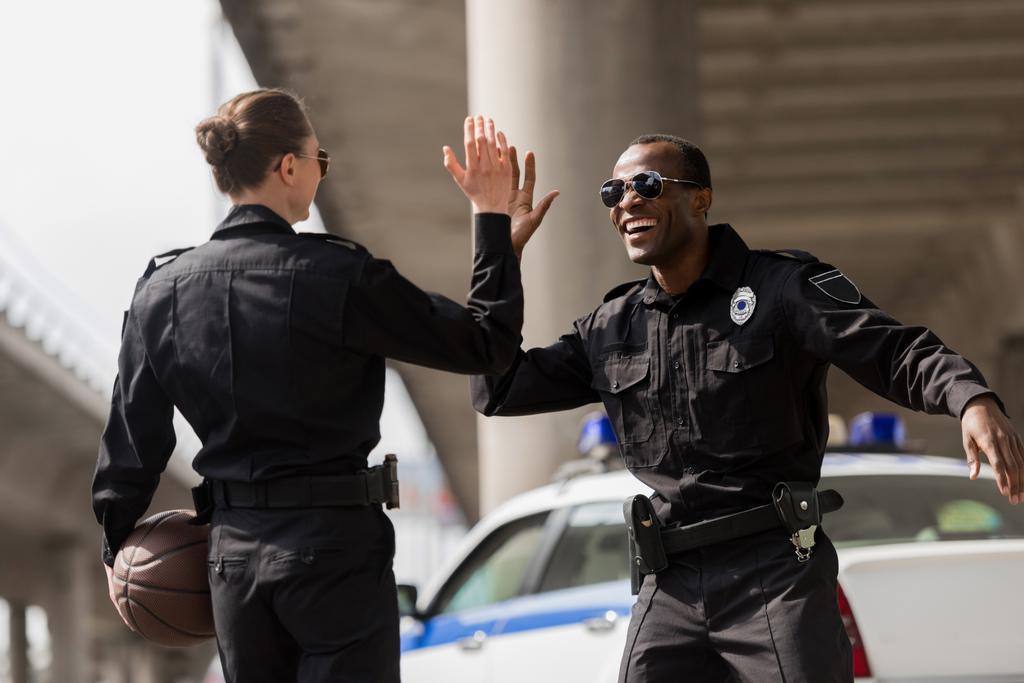 Policjanci z piłkę do koszykówki dając piątkę - Zdjęcie, obraz