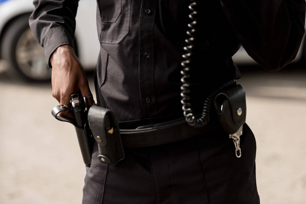 Polis memuru üniforma silahı alarak atış kırpılmış - Fotoğraf, Görsel