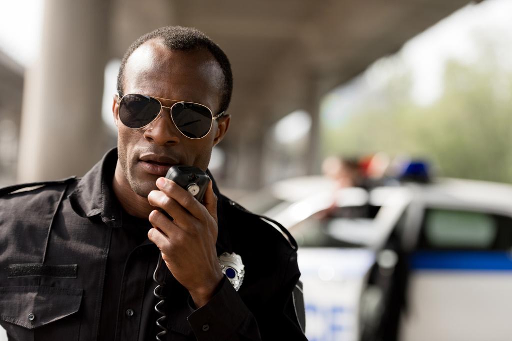 Μιλώντας από φορητό ραδιοτηλέφωνο ραδιόφωνο Αφρικανικός Αμερικανός αξιωματικός της αστυνομίας που - Φωτογραφία, εικόνα