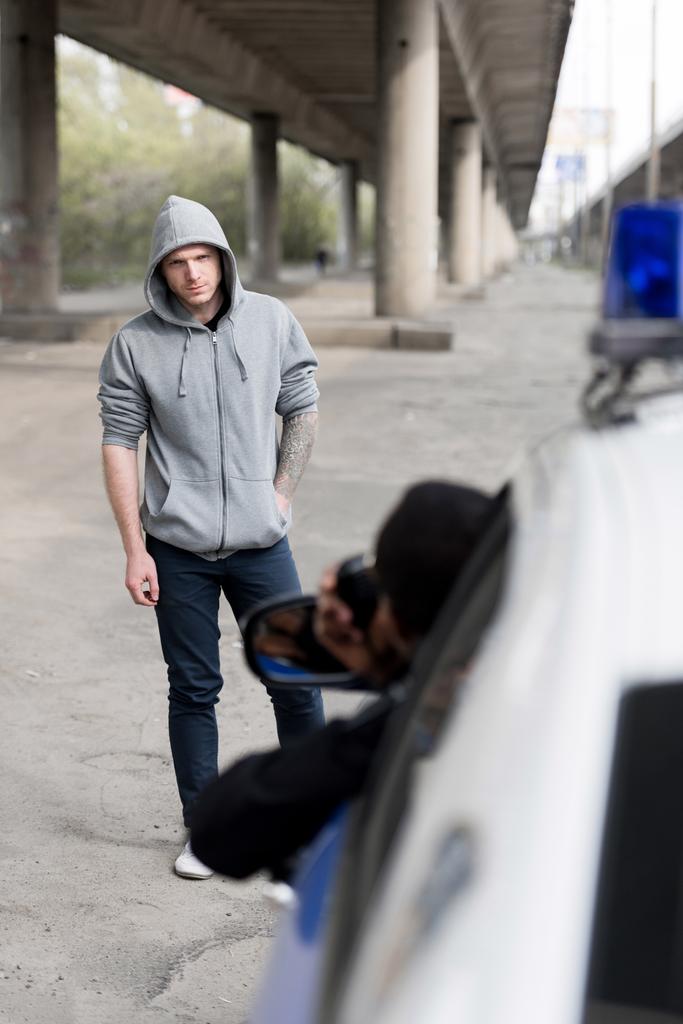 kapüşonlu genç adam sokakta pencereden dışarı bakıp polis - Fotoğraf, Görsel
