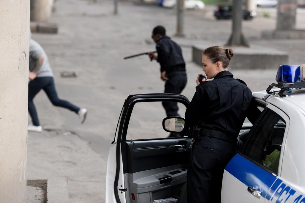 agentes de policía con coche persiguiendo ladrón en la calle
 - Foto, imagen