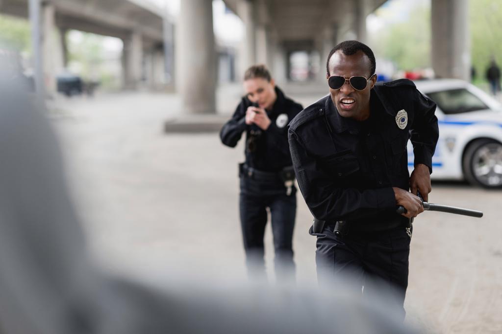 multi-etnische politie-agenten lopen voor de dief - Foto, afbeelding