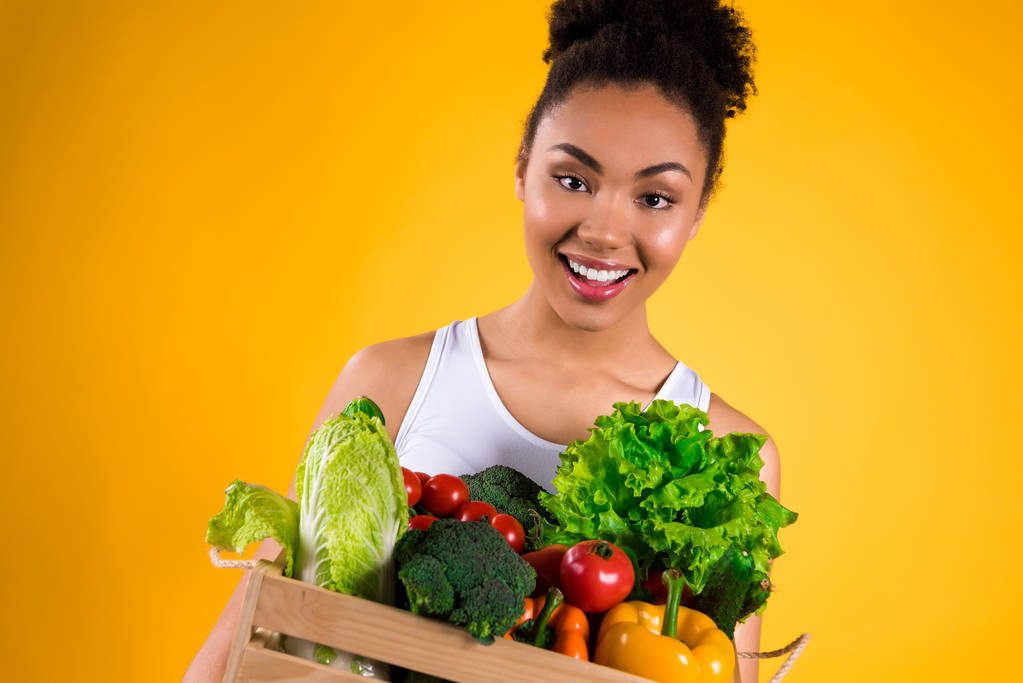 Chica negra con cajón de verduras aisladas
. - Foto, Imagen