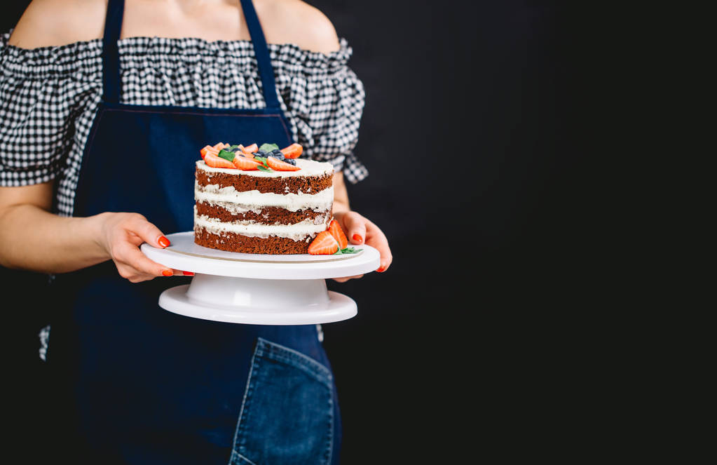 Pin-up styled woman presenting cake - Photo, Image