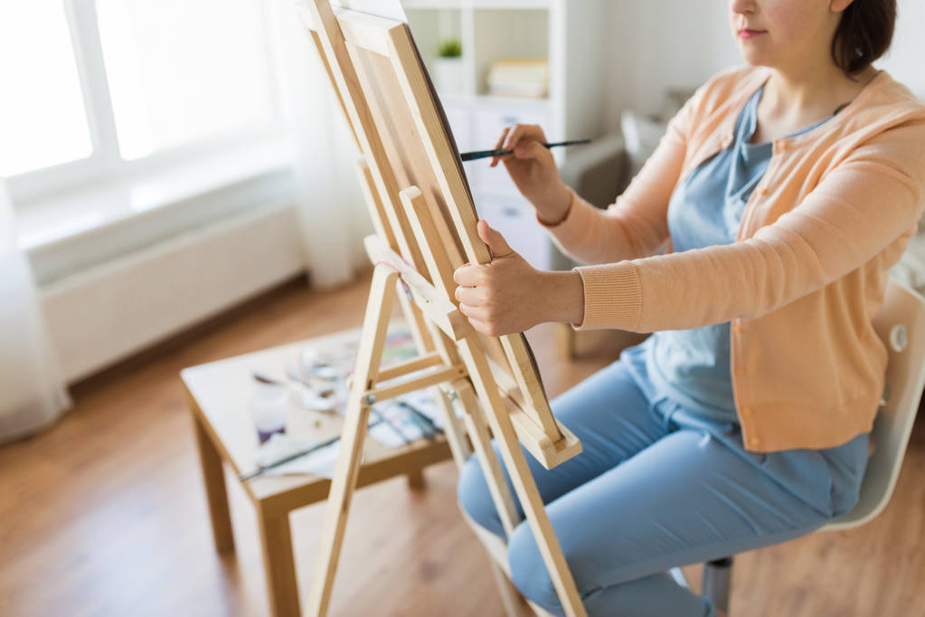 artista con caballete y pintura al pincel en el estudio de arte
 - Foto, Imagen