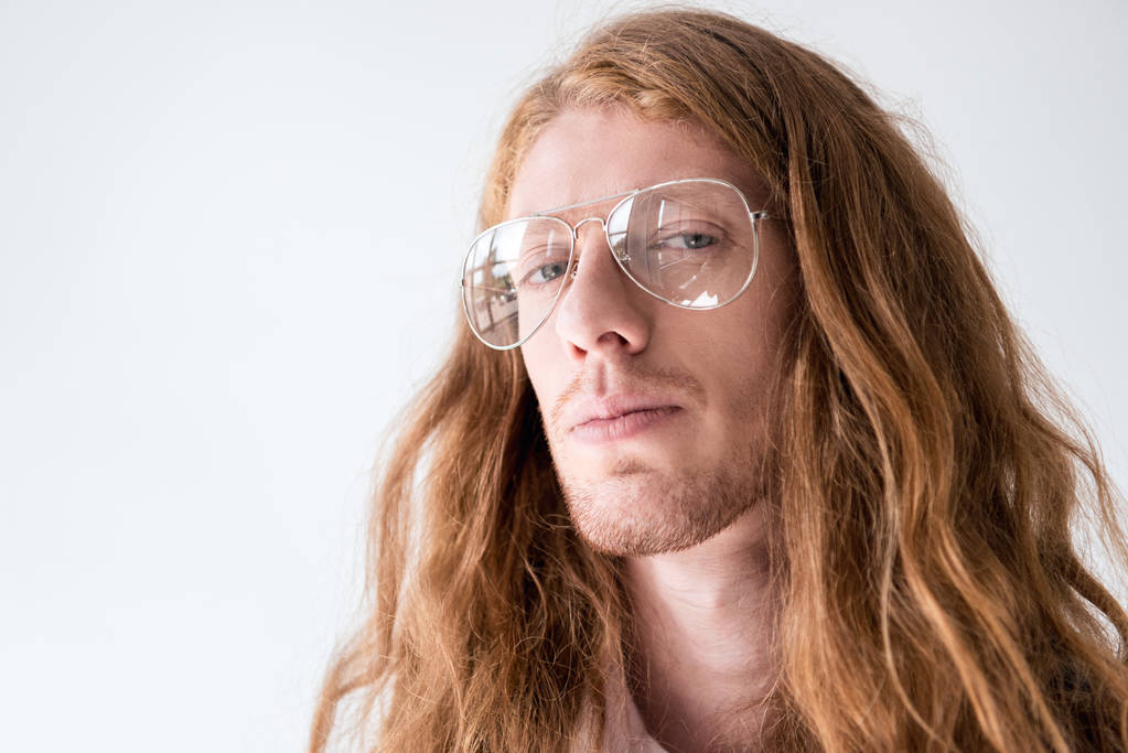 portrait of handsome man with curly ginger hair and glasses looking at camera isolated on white  - Photo, Image