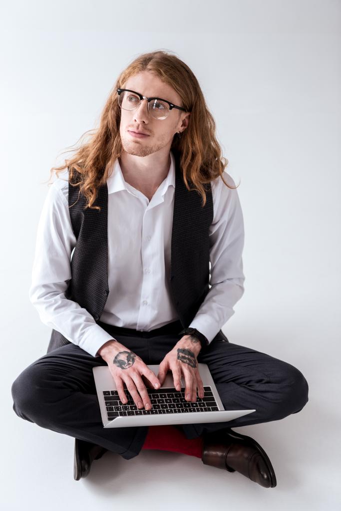 スタイリッシュなノート パソコンを床の上に座って巻き毛を持つ実業家を入れ墨 - 写真・画像