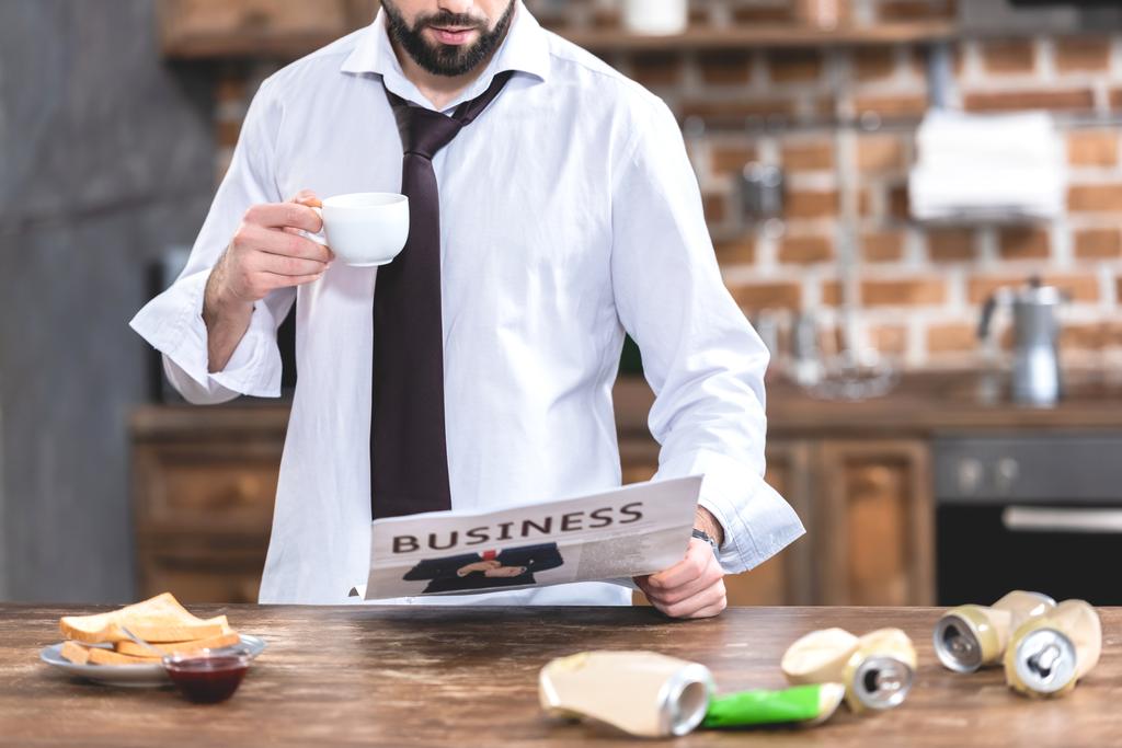 コーヒーを飲むと、朝のキッチンで新聞を読んで孤独実業家の画像をトリミング - 写真・画像