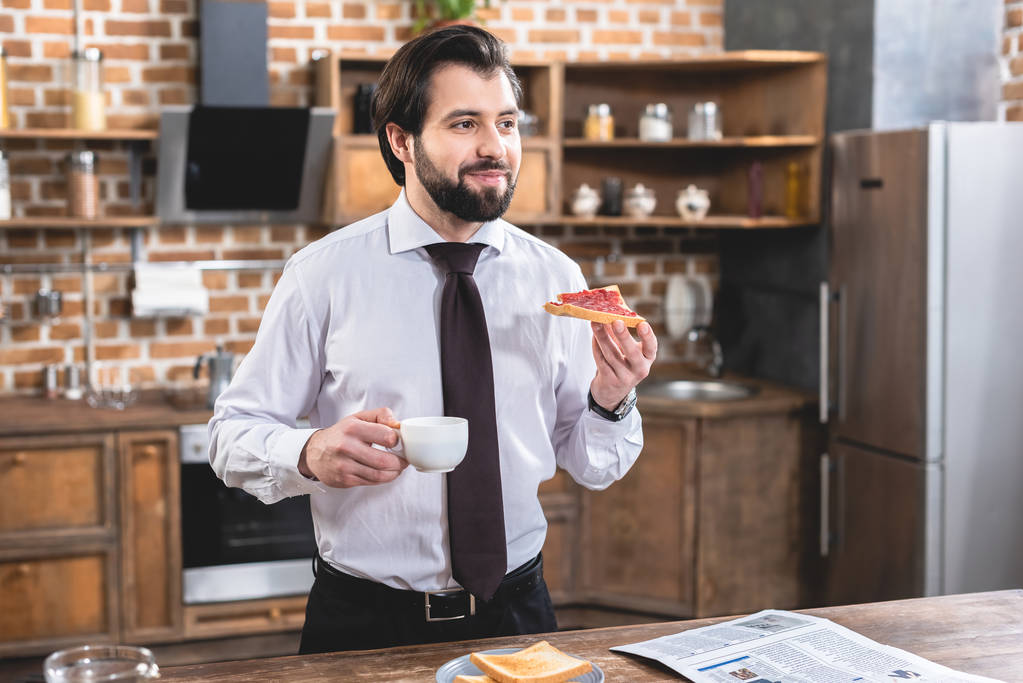 красивый одинокий бизнесмен завтракает на кухне
 - Фото, изображение