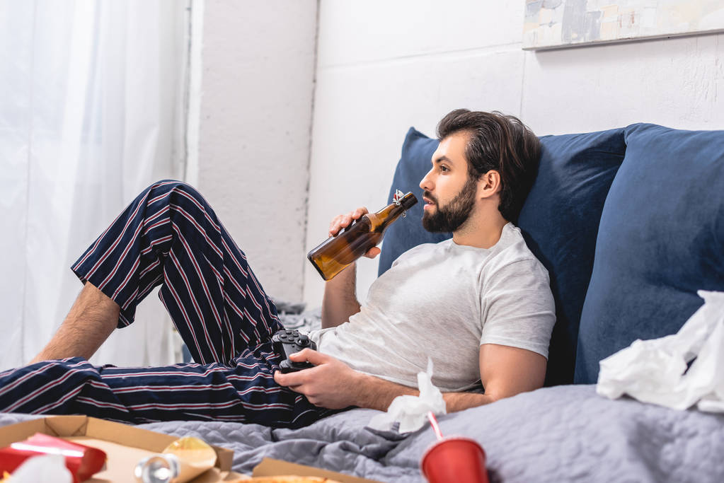 mâle solitaire jouer jeu vidéo dans chambre et boire de la bière
 - Photo, image