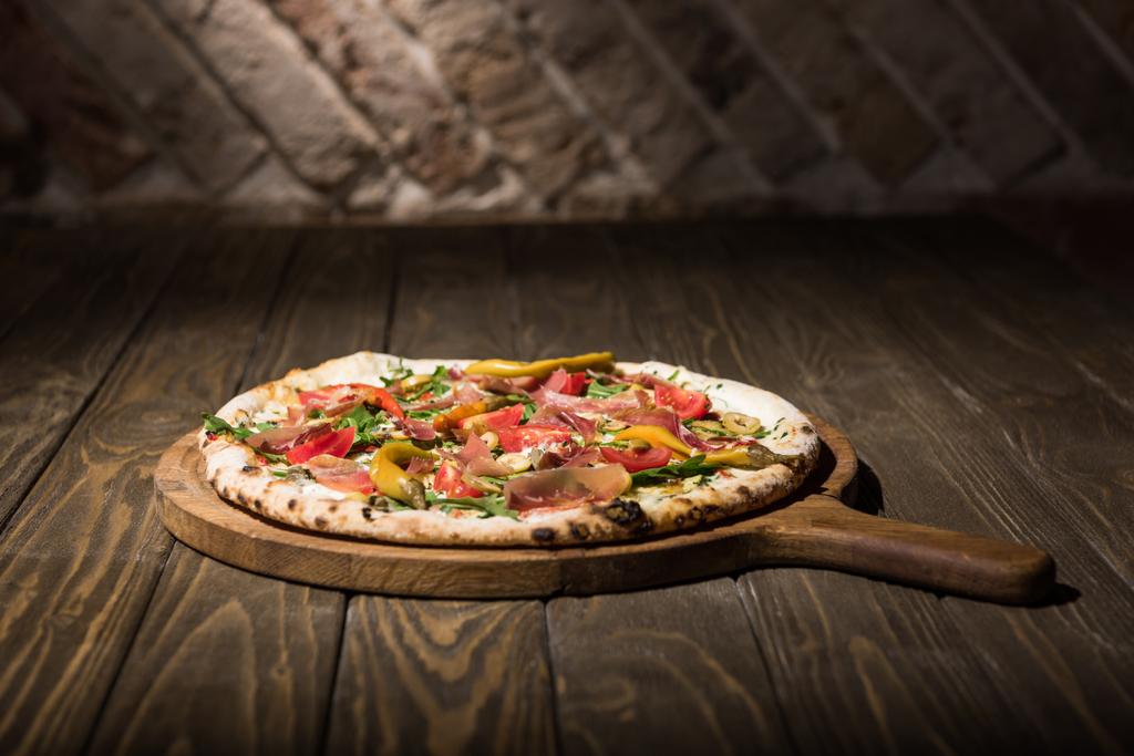 крупним планом вид італійської піци на обробній дошці на дерев'яній стільниці
 - Фото, зображення