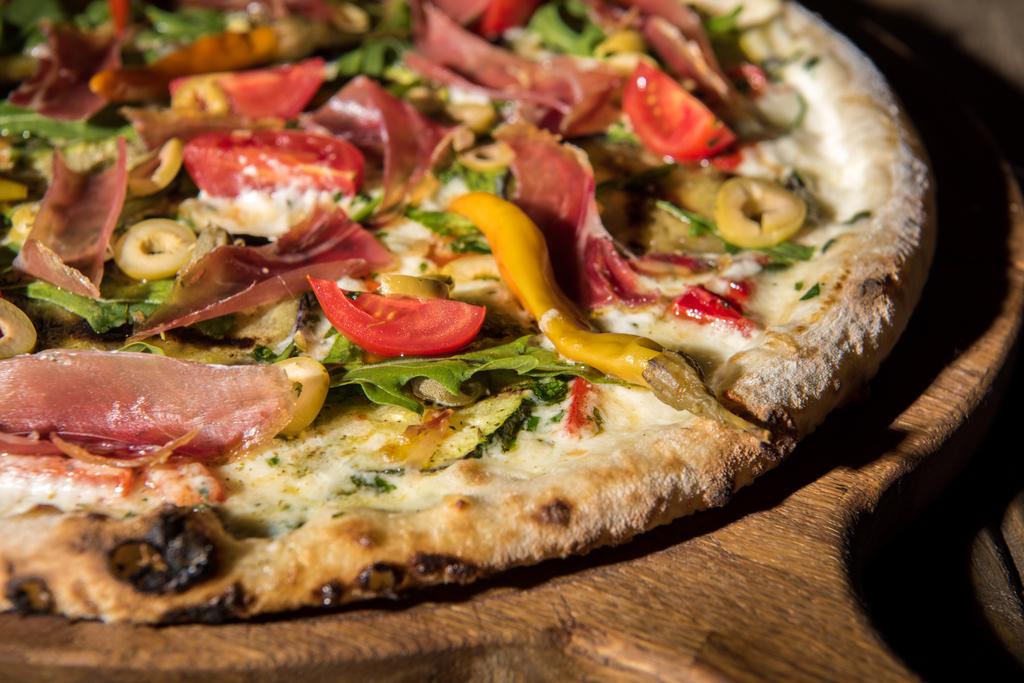 zblízka pohled čerstvě upečené italskou pizzu na dřevěném prkénku - Fotografie, Obrázek