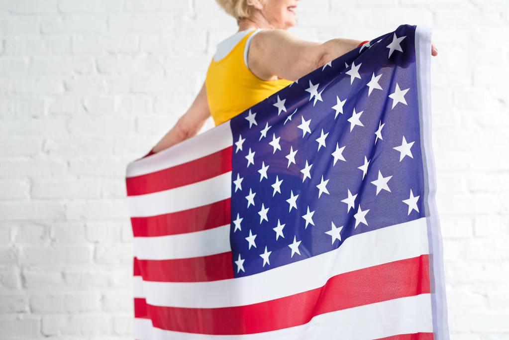 Oříznout záběr senior sportovkyně drží Americká vlajka - Fotografie, Obrázek