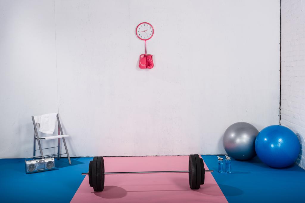 barbell, bokshandschoenen, fit ballen en tape recorder in sportschool - Foto, afbeelding