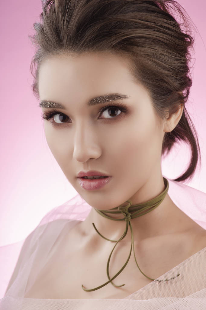 Vértes portré egy szép fiatal ázsiai lány visel rózsaszín ve - Fotó, kép