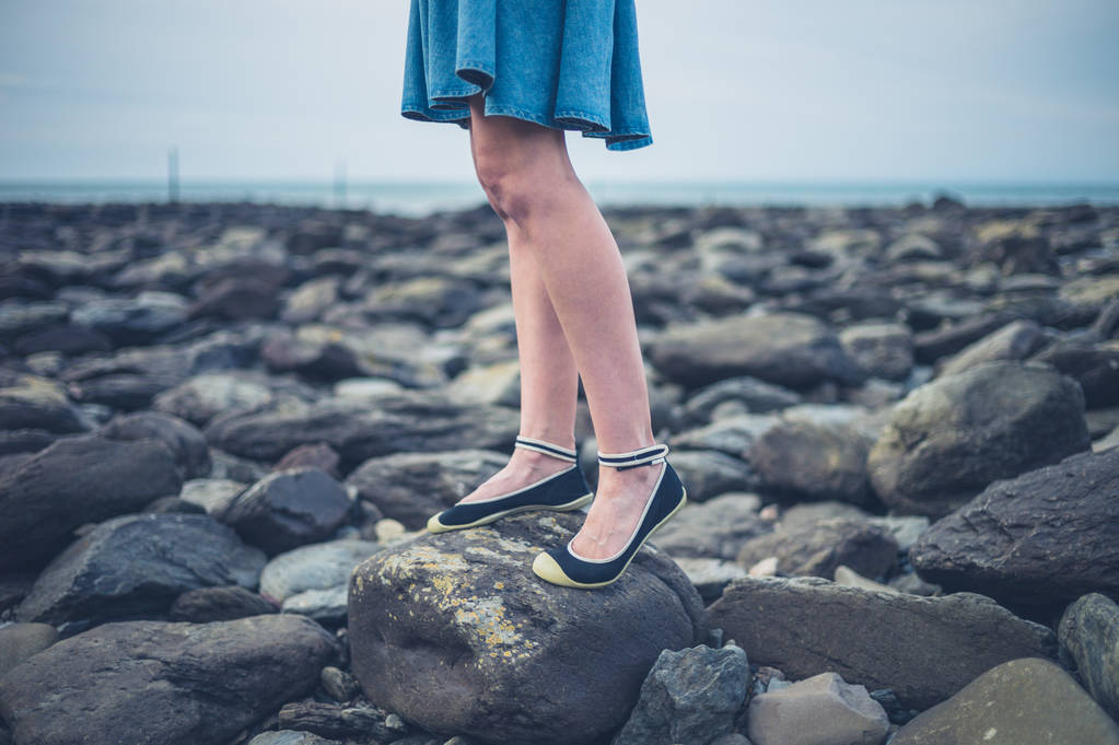 Πόδια και τα πόδια του νεαρή γυναίκα στην παραλία το φθινόπωρο - Φωτογραφία, εικόνα
