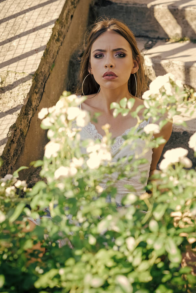Mladá žena představují na kvetoucí bush na slunečný den, letní. - Fotografie, Obrázek