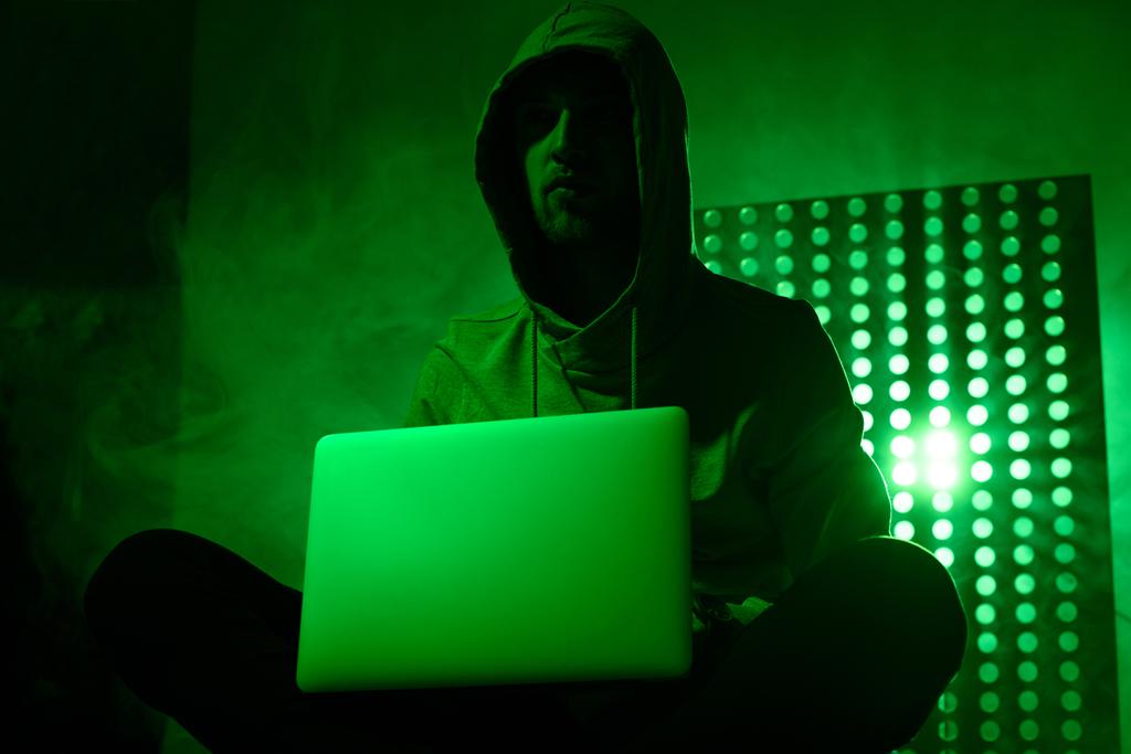 foto tonica di hacker maschile in felpa con cappuccio con computer portatile
 - Foto, immagini
