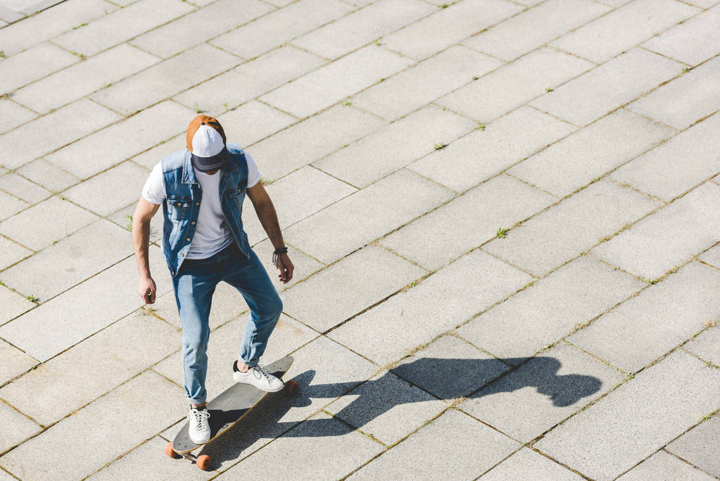 vista de alto ângulo de elegante skatista jovem montando longboard por quadrado
 - Foto, Imagem