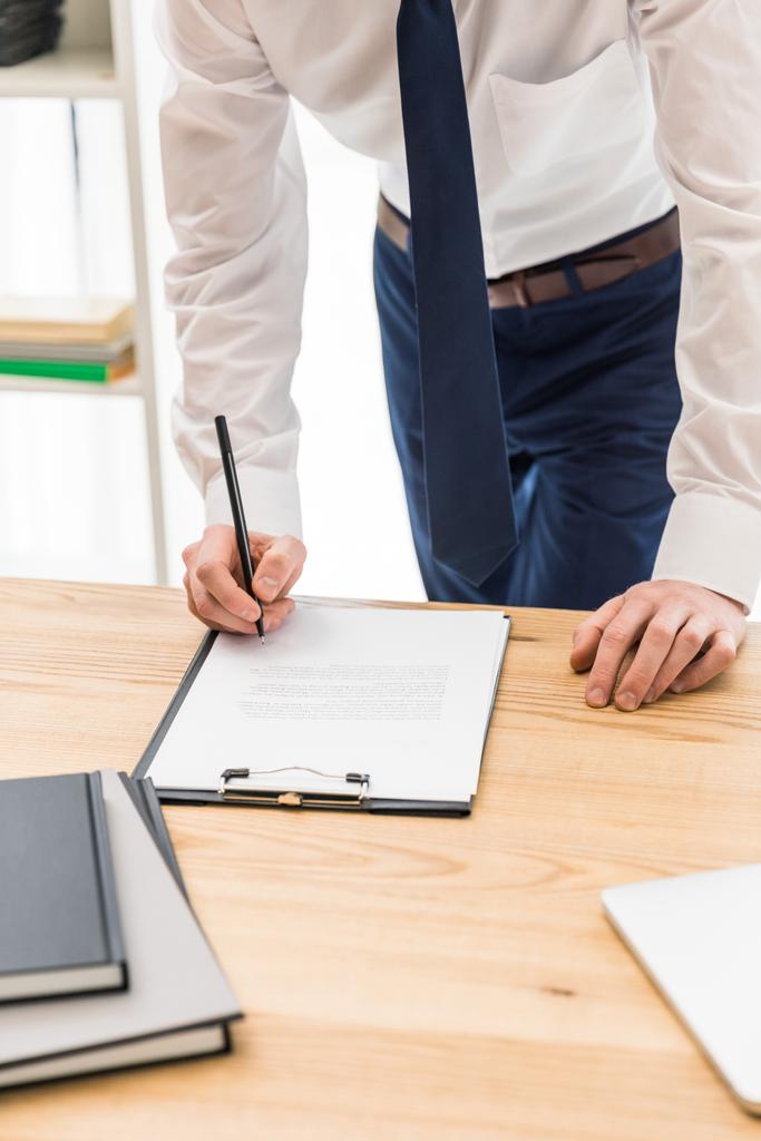 partial view of businessman signing papers at workplace in office  - Photo, Image