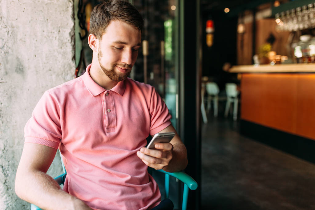 Jonge man zitten in cafe met laptop en telefoon, werken, winkelen online, hipster - Foto, afbeelding