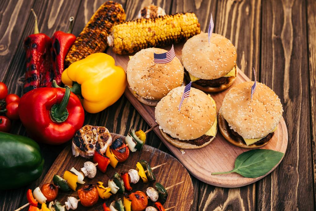 Cena de día de independencia con hamburguesas y verduras cocinadas al aire libre a la parrilla
 - Foto, imagen