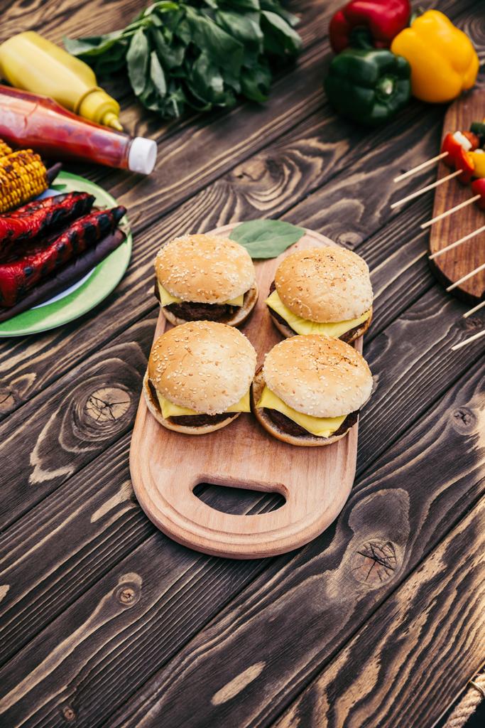 geschnittenes Gemüse und gegrillte Burger für Grillen im Freien - Foto, Bild