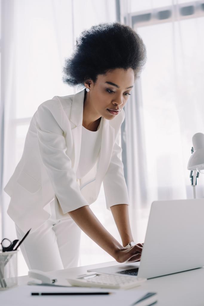 atraente mulher de negócios afro-americana usando laptop no escritório
 - Foto, Imagem