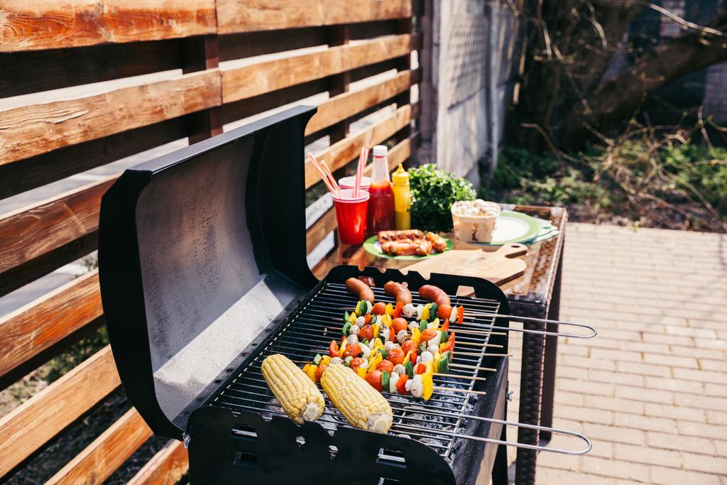 Seizoensgebonden groenten en worst gekookt buitenshuis op grill - Foto, afbeelding