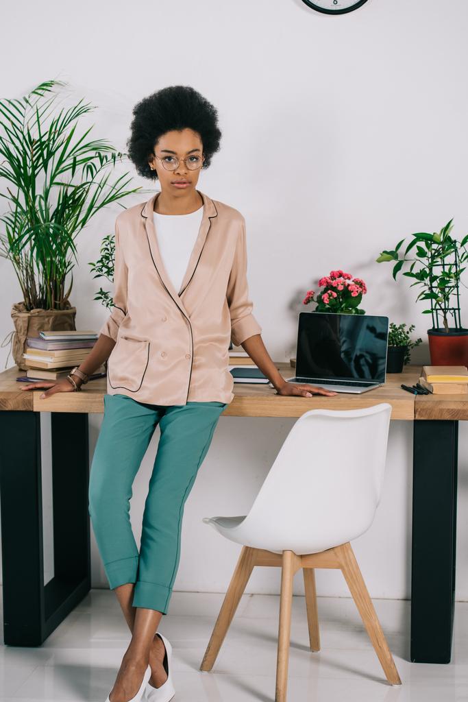 vonzó afro-amerikai üzletasszony hivatalban asztalon hajol - Fotó, kép