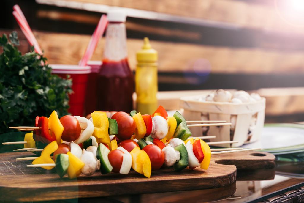 Vegetables on skewers with ketchup and mustard cooked outdoors  - Photo, Image