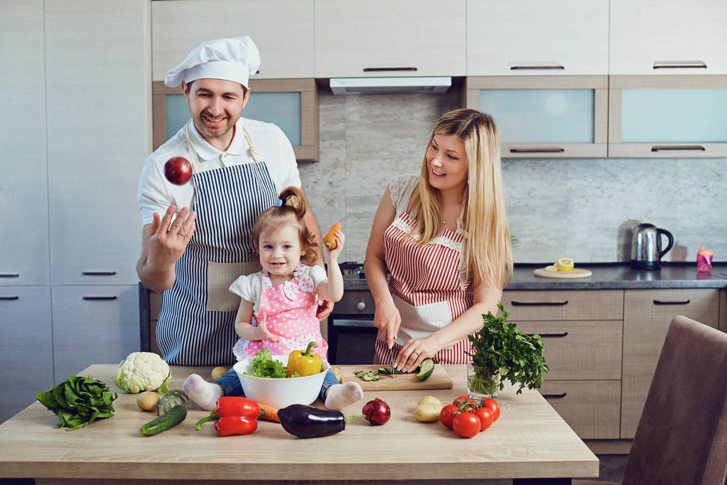 Una famiglia felice prepara il cibo in cucina
. - Foto, immagini