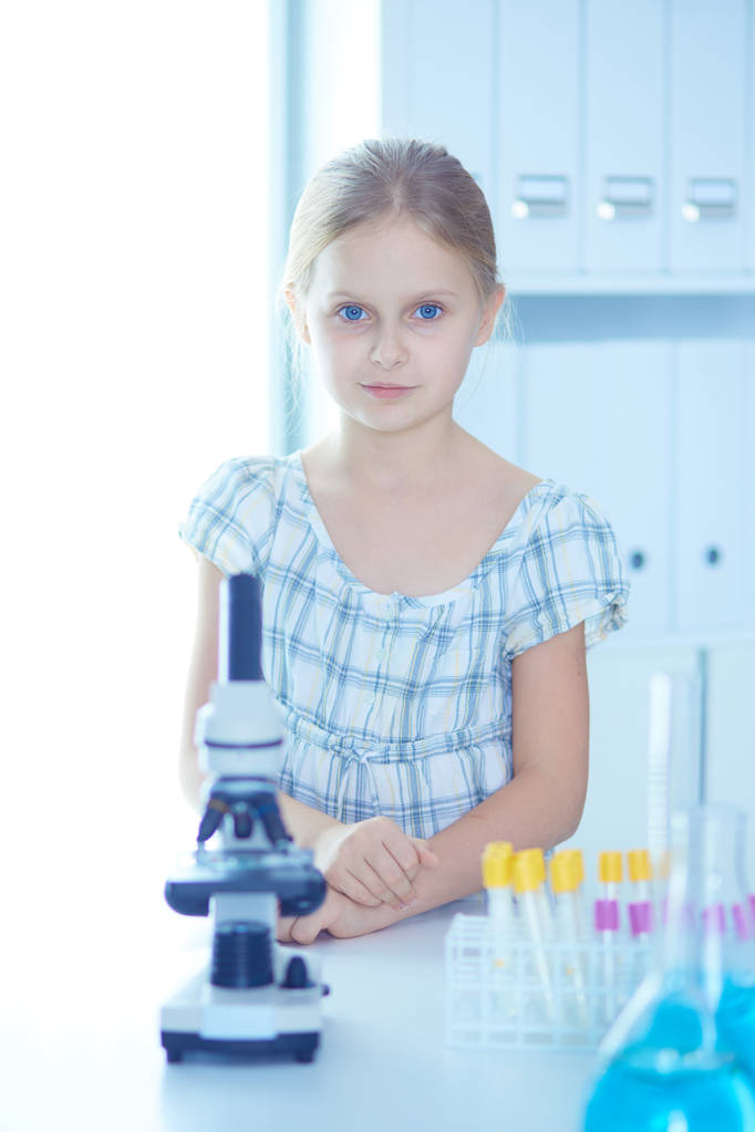uczennica wyglądający za pomocą mikroskopu w klasie nauki. - Zdjęcie, obraz