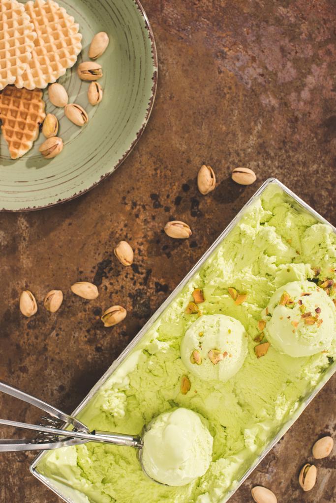 テーブルのスクープと緑のピスタチオ アイス クリームのトップ ビュー - 写真・画像