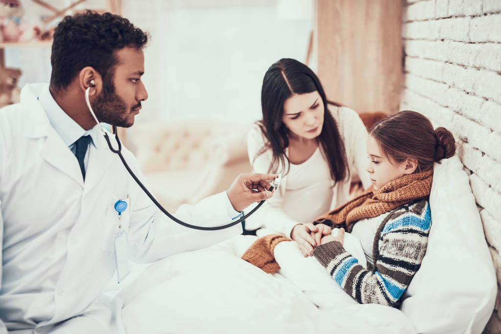 Indyjski lekarz widząc pacjentów w domu. Lekarz jest za pomocą stetoskopu. W ciąży matka i córka. - Zdjęcie, obraz