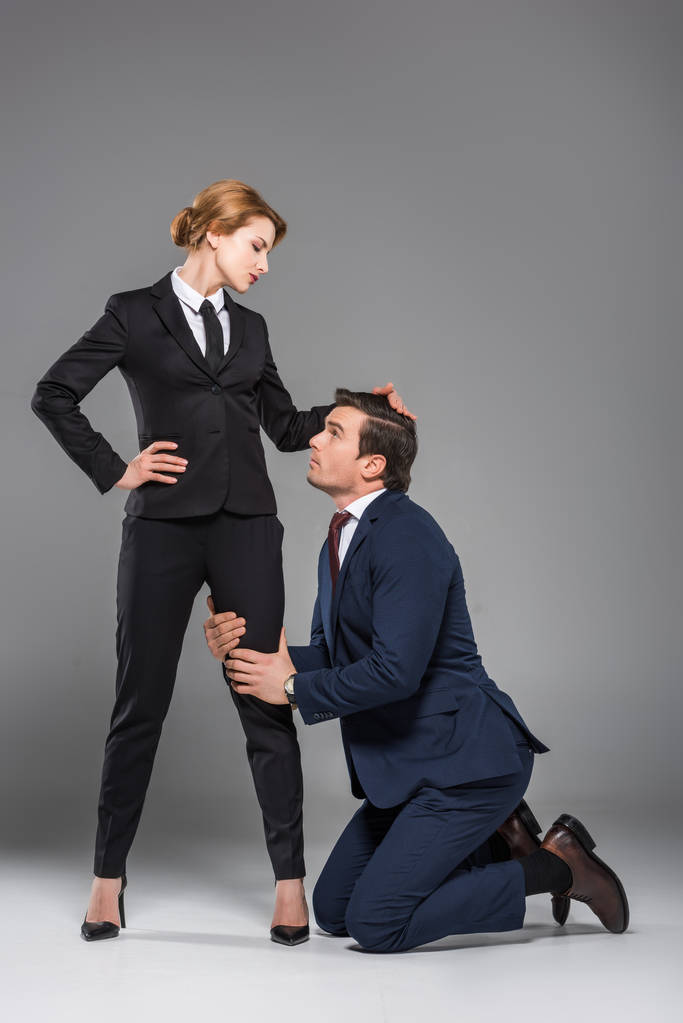 γυναίκα αφεντικό που δεσπόζει πάνω από την φοβισμένη επιχειρηματίας, απομονώνονται σε γκρι, φεμινισμός έννοια - Φωτογραφία, εικόνα