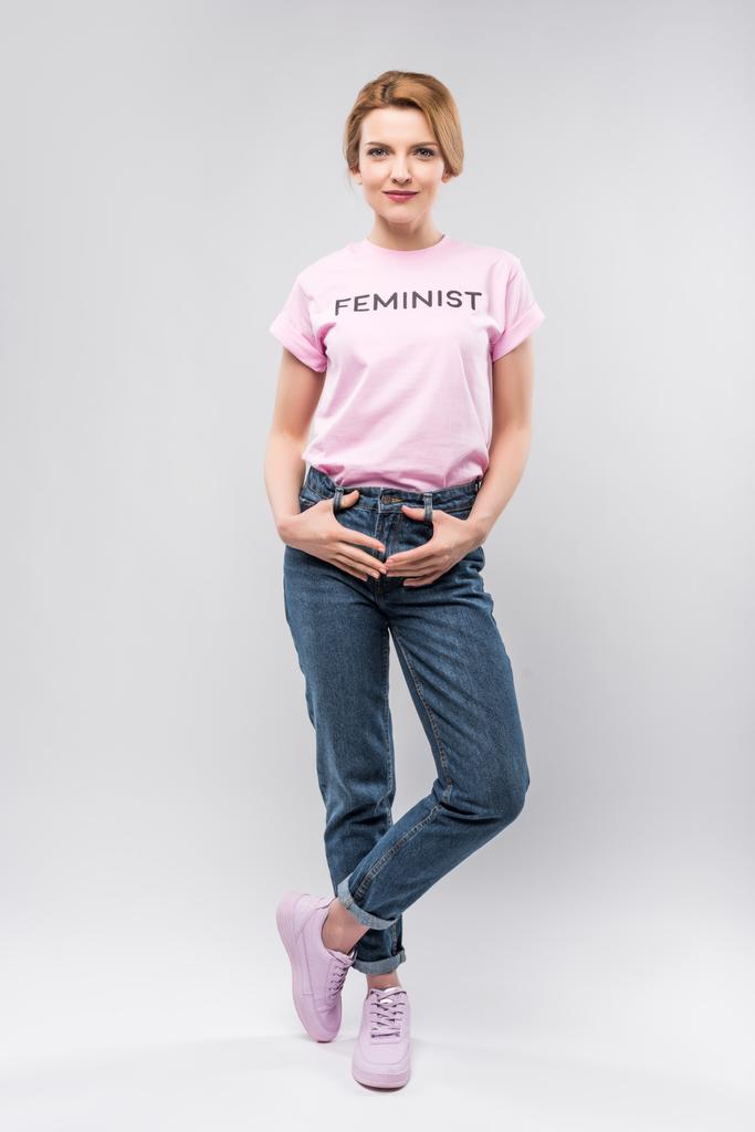 魅力的な女性がピンクのフェミニストのポーズ t シャツ、グレーの分離 - 写真・画像