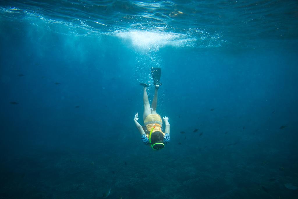 Unterwasserfoto einer Frau in Flossen, Tauchermaske und Schnorcheltauchen allein im Ozean - Foto, Bild