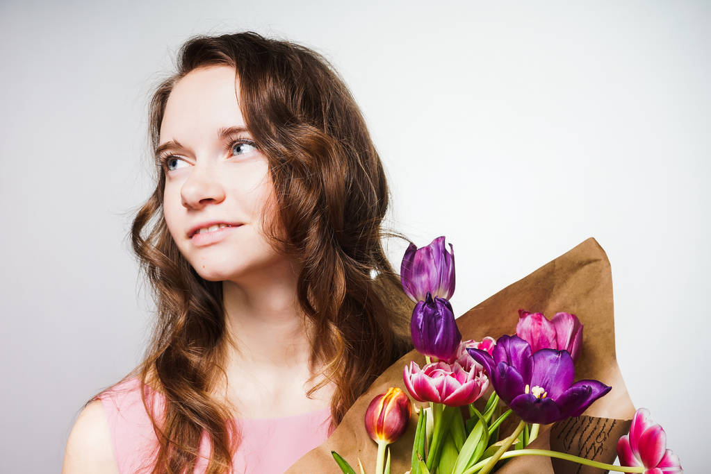 attraktive junge Frau hält einen großen Strauß duftender Blumen in der Hand und feiert Muttertag - Foto, Bild