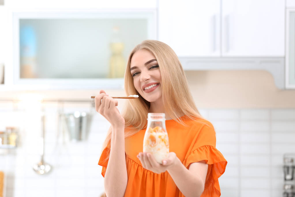 Молодая женщина с йогуртом на кухне
 - Фото, изображение