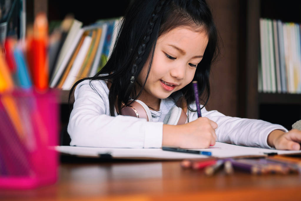 мила дівчина посміхнулася і сіла, щоб намалювати книгу в бібліотеці, дитяча концепція, концепція освіти
 - Фото, зображення