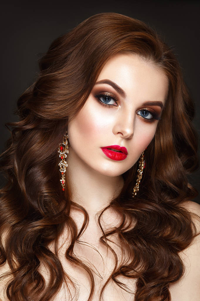 Mooie vrouw portret met krullend haar, rode oorbellen en avond make-up. - Foto, afbeelding