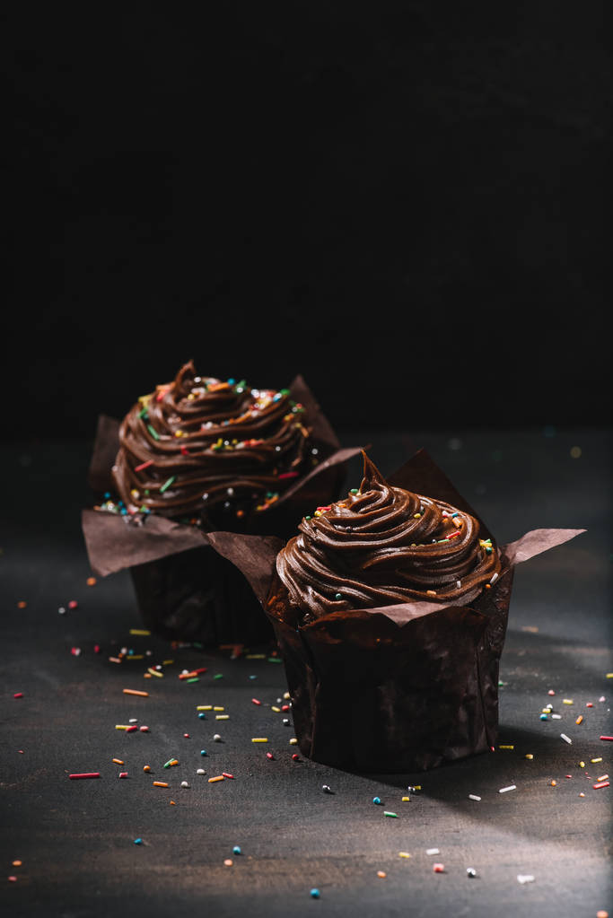 Appetizing chocolate cupcakes with buttercream glaze on table - Photo, Image