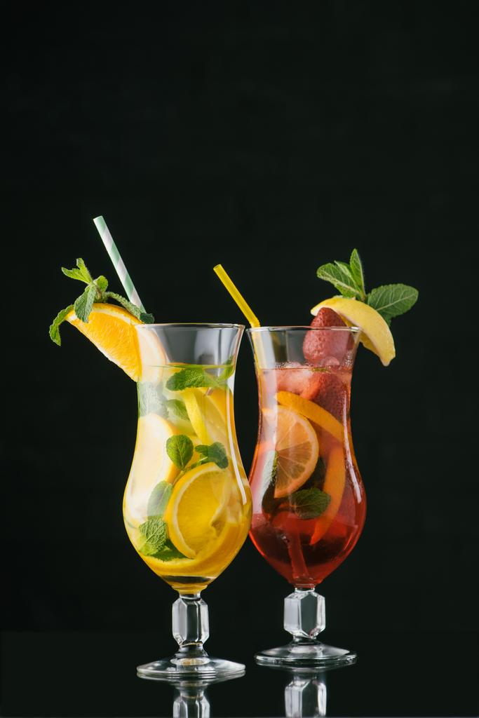 pohled letních osvěžujících nealkoholických koktejlů s mátou a citrusové kusů izolované na černém pozadí na plochu - Fotografie, Obrázek
