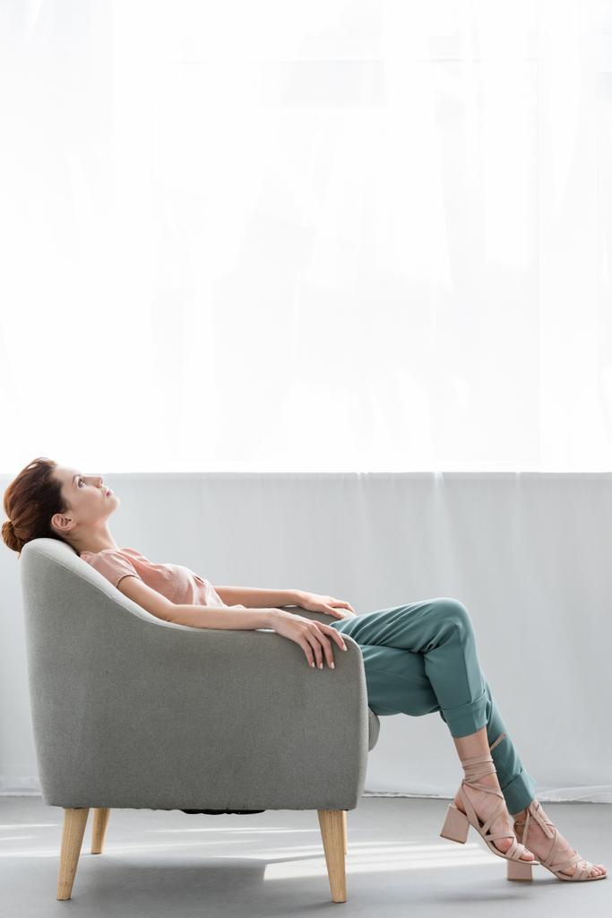 attrayant jeune femme relaxant sur fauteuil confortable à la maison
 - Photo, image